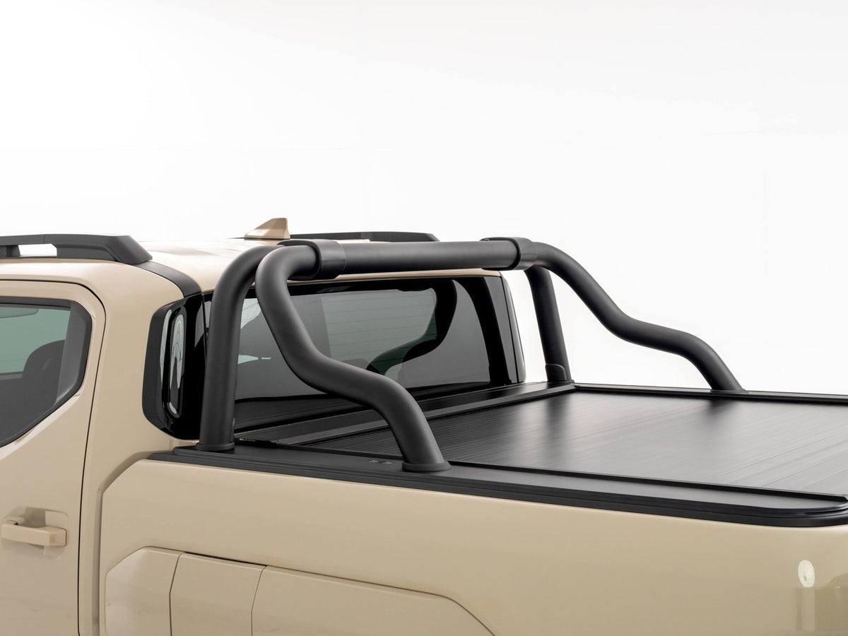 Close-up view of a Kia Tasman tub showing the HSP Roll R electric roller cover closed, with black tubular sports bars mounted above the cover behind the cab.